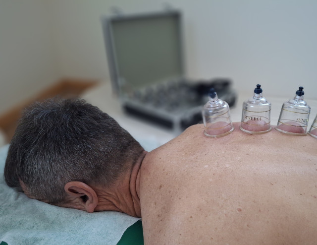 Close-up hands applying shiatsu pressure on shoulders, serene spa ambience